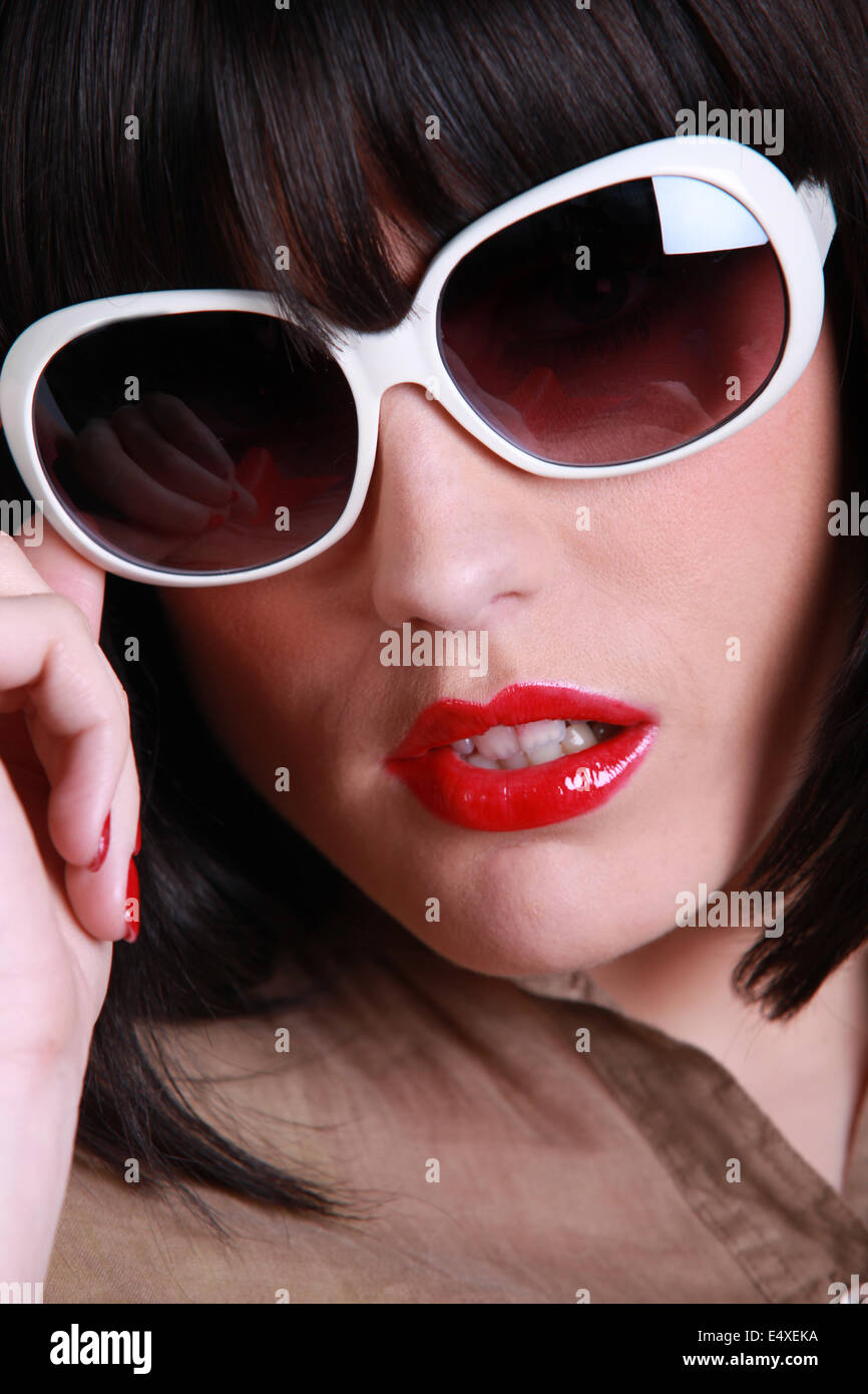 Close up brunette indossando occhiali da sole Foto Stock