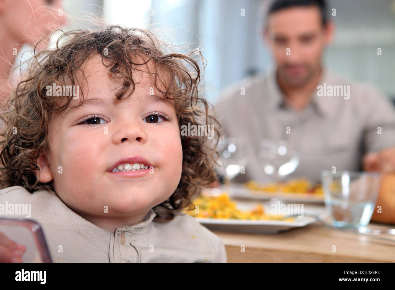 Ragazza giovane con un pasto con la famiglia Foto Stock