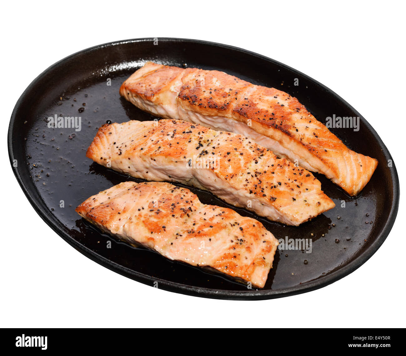 Fritto di filetti di salmone in un piatto di ferro isolato su sfondo bianco Foto Stock