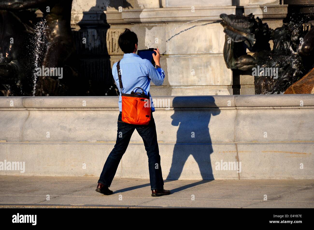 Washington, DC: Asian tourist usando un tampone scatta una fotografia della fontana di Nettuno davanti alla Biblioteca del Congresso * Foto Stock