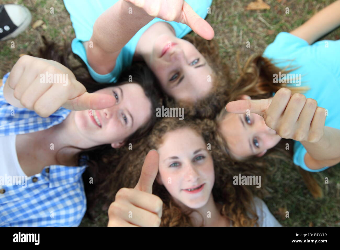 Felice quattro ragazze adolescenti dando Thumbs up Foto Stock