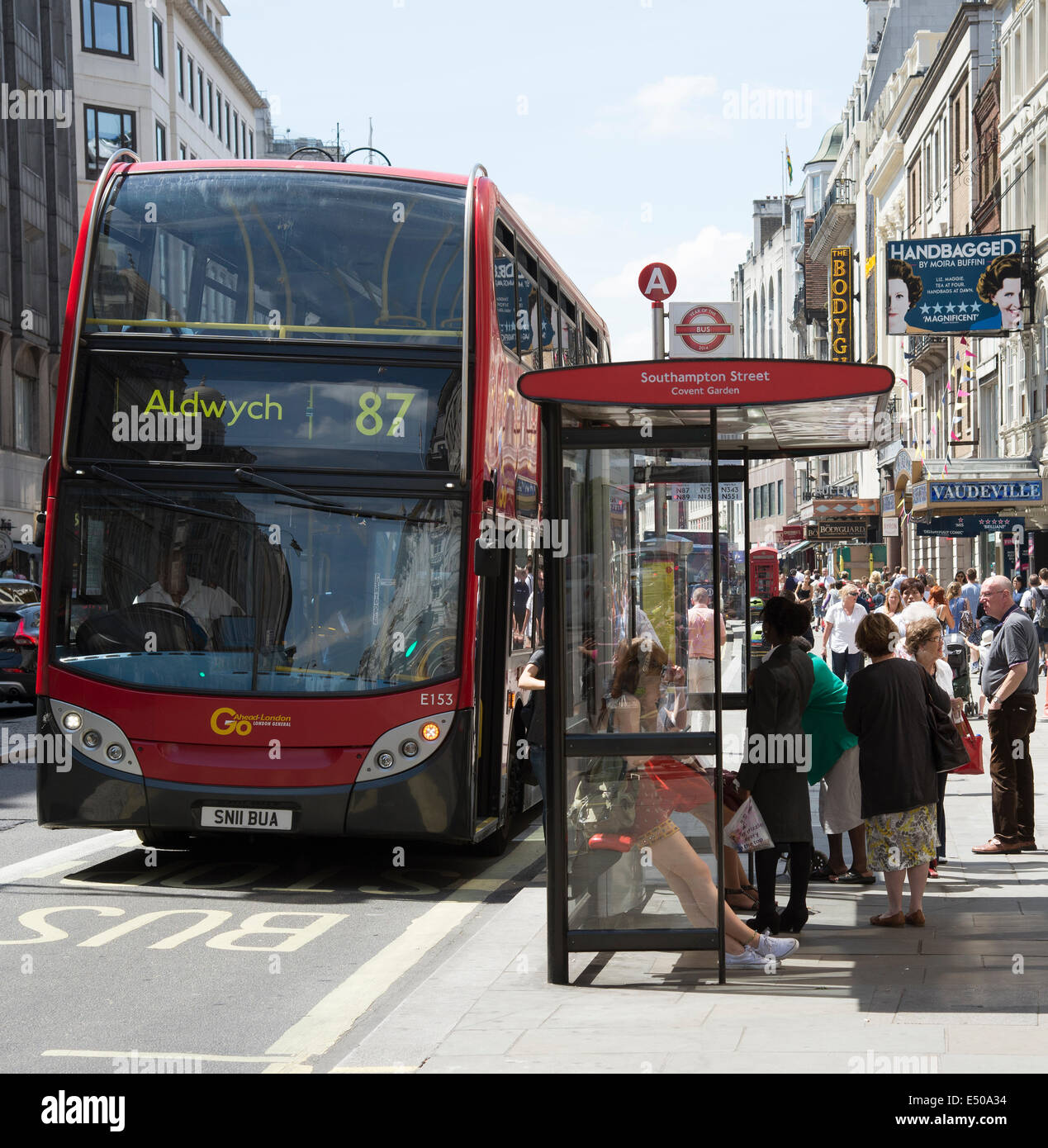 The Strand Londra UK affollati di visitatori bus rosso presso la fermata degli autobus numero 87 legato per l'Aldwych Foto Stock