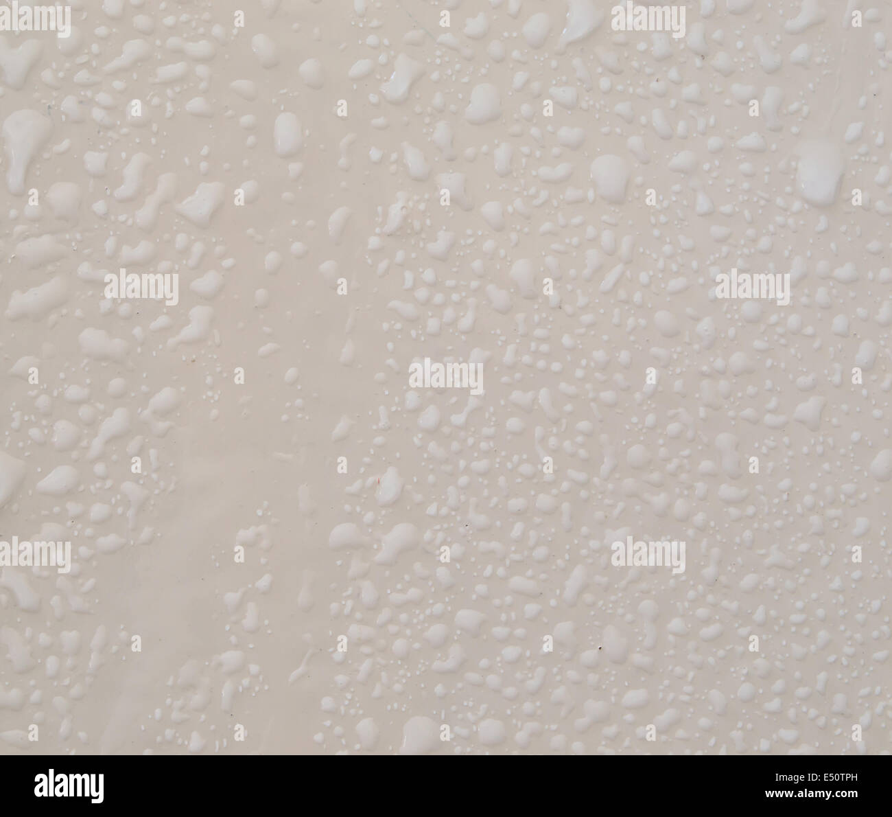 Gocce di pioggia sulla crema parete colorata Foto Stock
