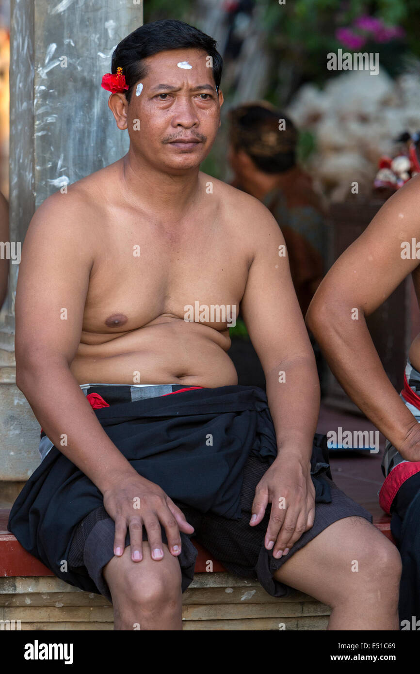 Bali, Indonesia. Uomo in attesa di inizio del kecak dance, Arena adiacente al Tempio di Uluwatu. Foto Stock