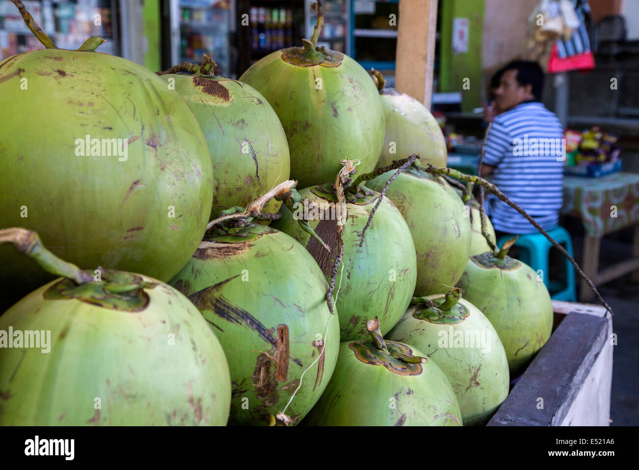 Jimbaran, Bali, Indonesia. Noci di cocco fresco al di fuori di un piccolo ristorante--per essere venduto come un drink rinfrescante. Foto Stock