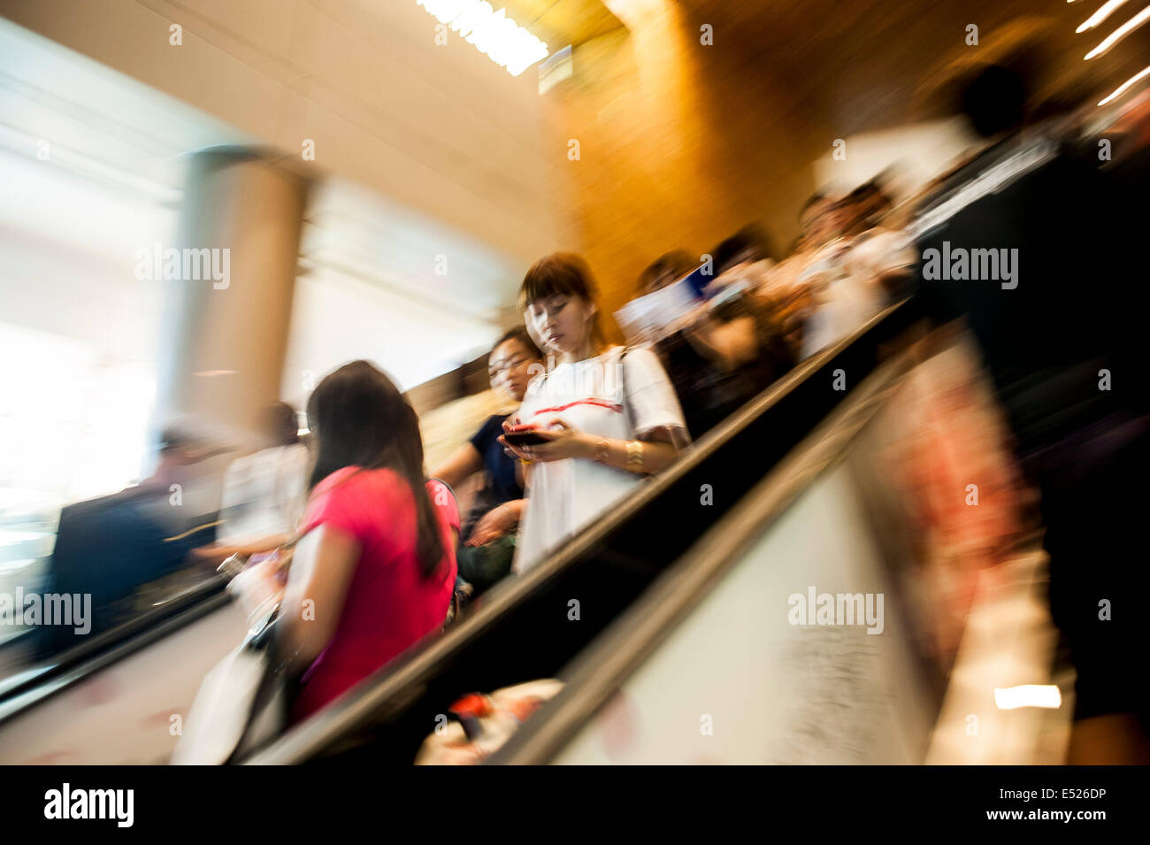 Persone su scala mobile ad un centro commerciale Foto Stock