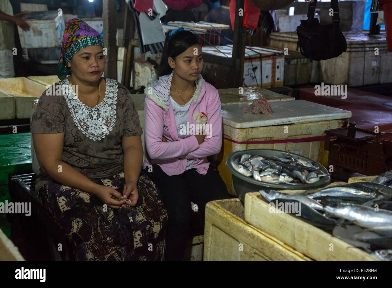 Bali, Indonesia. Madre e figlia in attesa per un cliente, Jimbaran Mercato del Pesce. Foto Stock