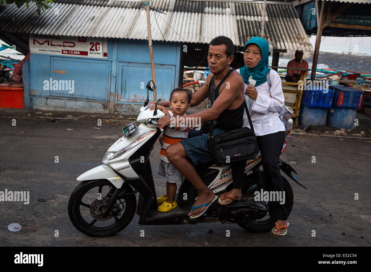 Bali, Indonesia. Famiglia arrivando a Jimbaran Mercato del Pesce in moto, caschi n. Foto Stock
