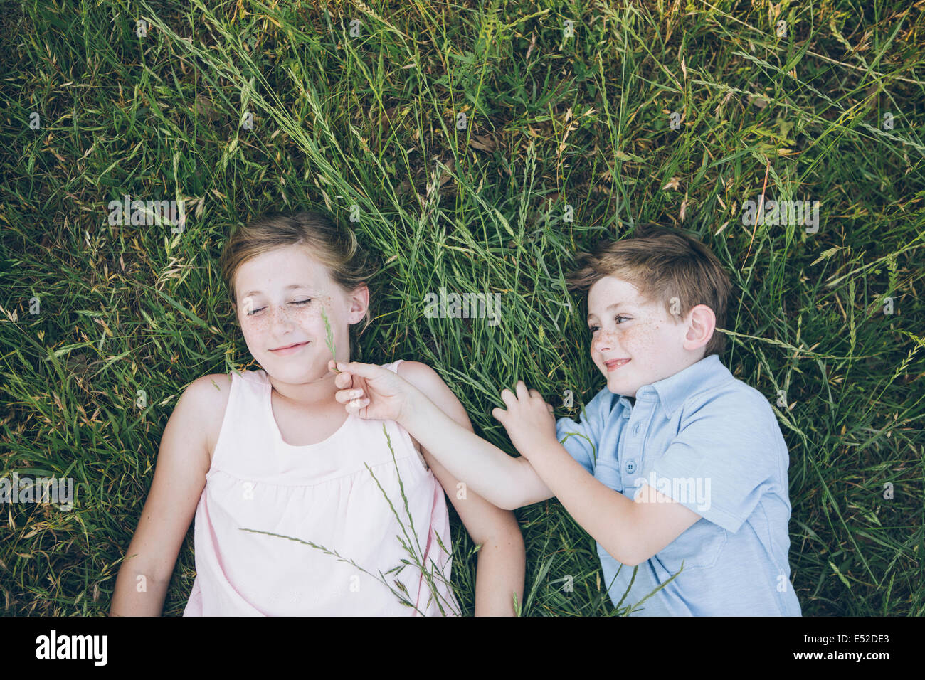 Due bambini, fratello e sorella affiancati sull'erba Foto Stock