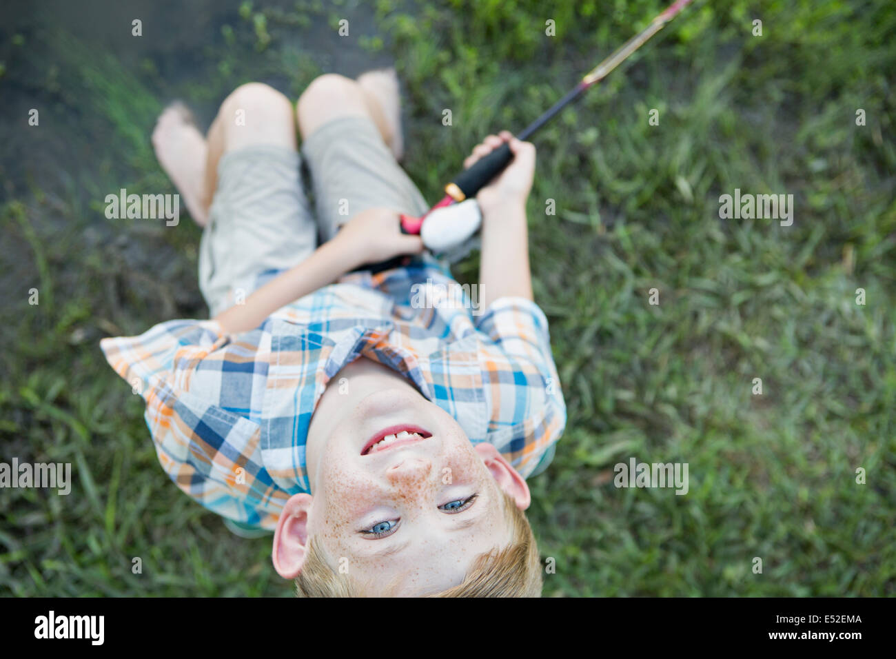 Un giovane ragazzo all'esterno guardando verso l'alto. Foto Stock