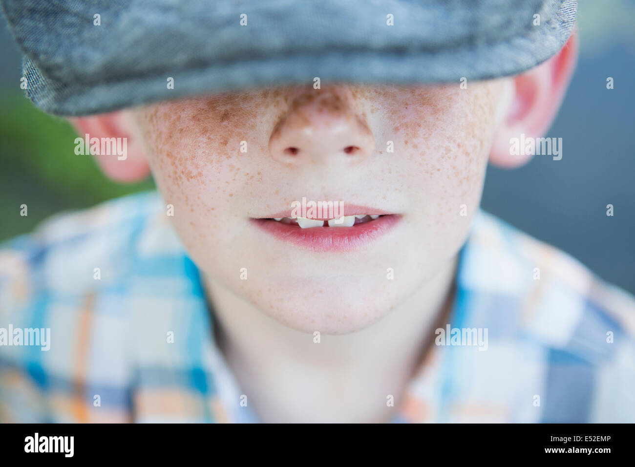Un giovane ragazzo con un naso freckled, indossando un cappello con un orlo di grandi dimensioni. Foto Stock