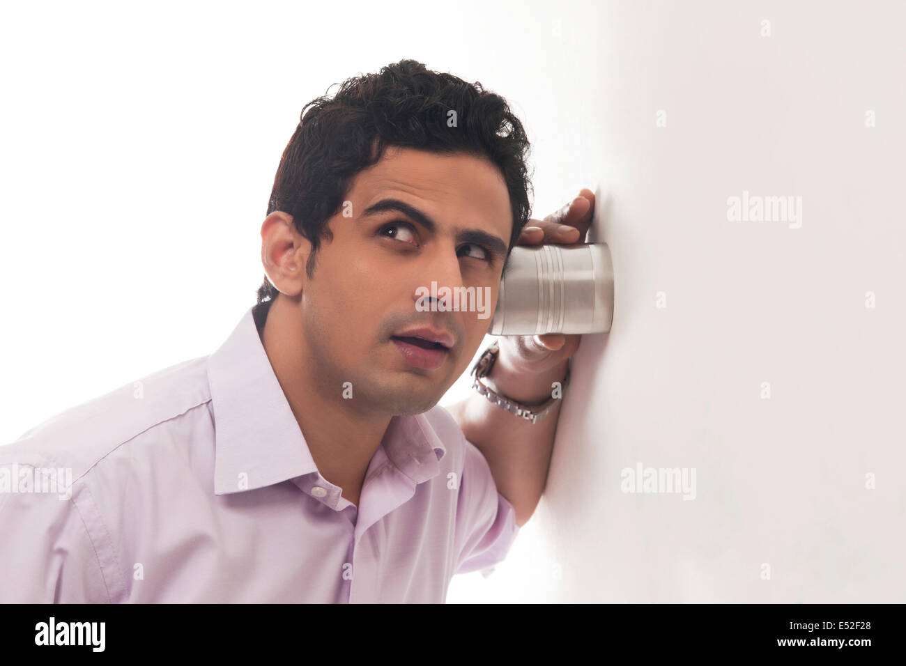 Uomo di vetro di contenimento contro la parete in ascolto Foto Stock