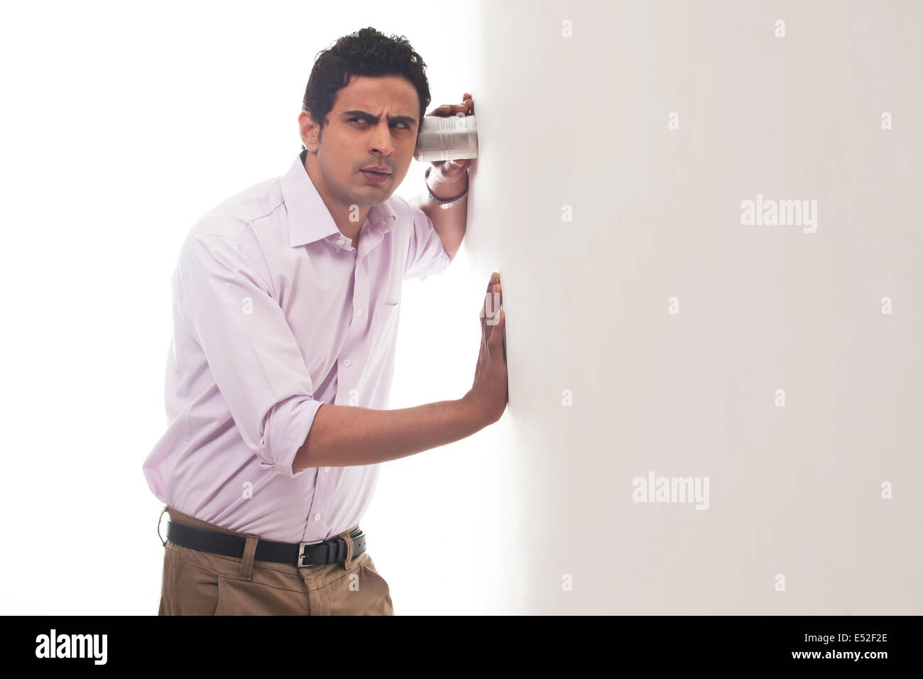 Uomo di vetro di contenimento contro la parete in ascolto Foto Stock