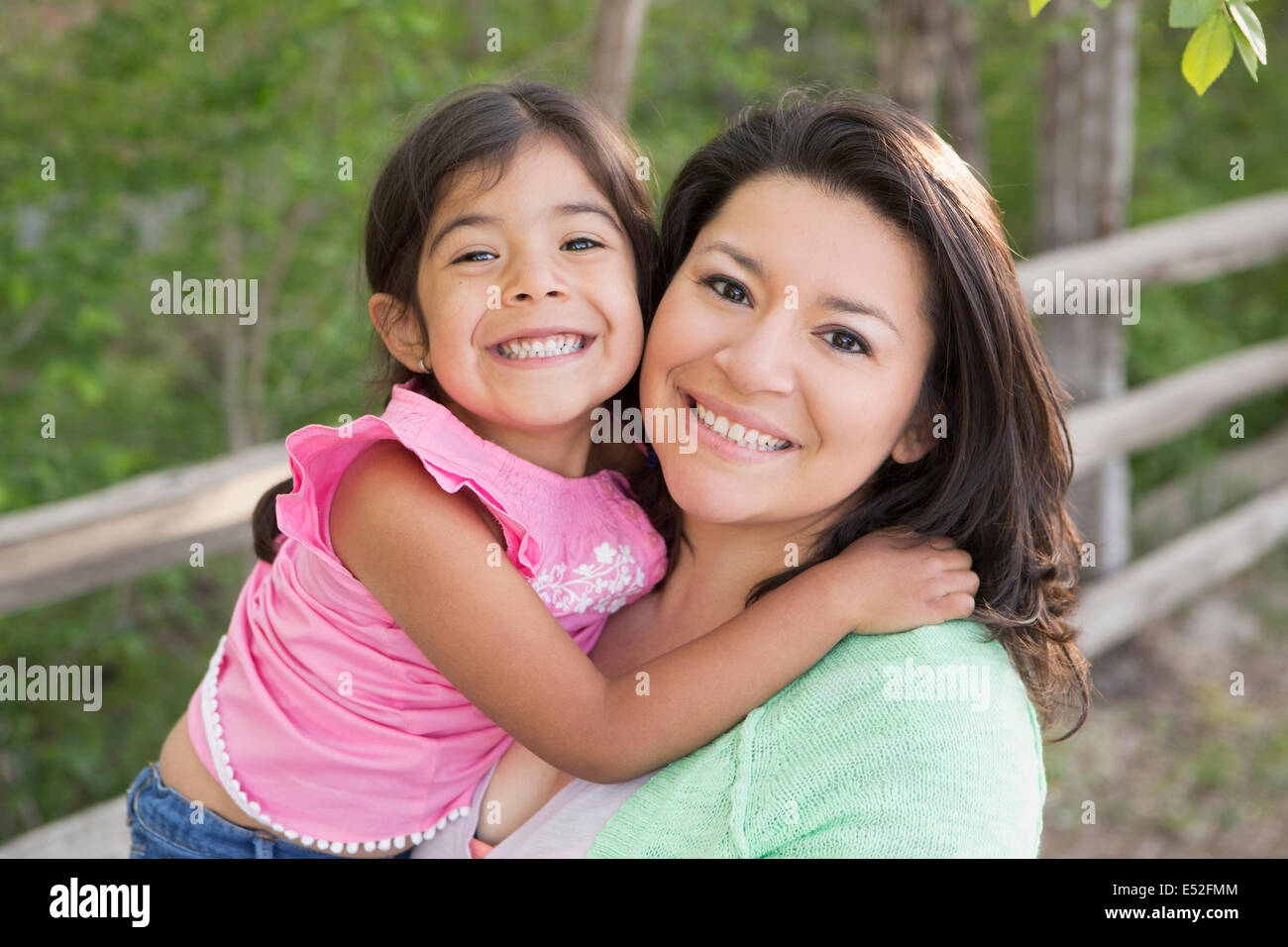 Una madre nel parco con sua figlia, ridendo e baciando ogni altro. Foto Stock