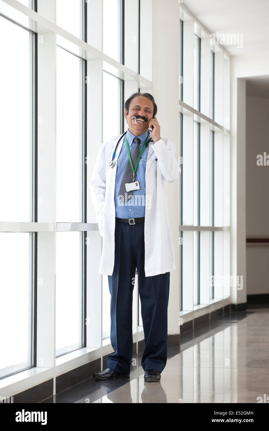 Medico a parlare su un telefono mobile Foto Stock