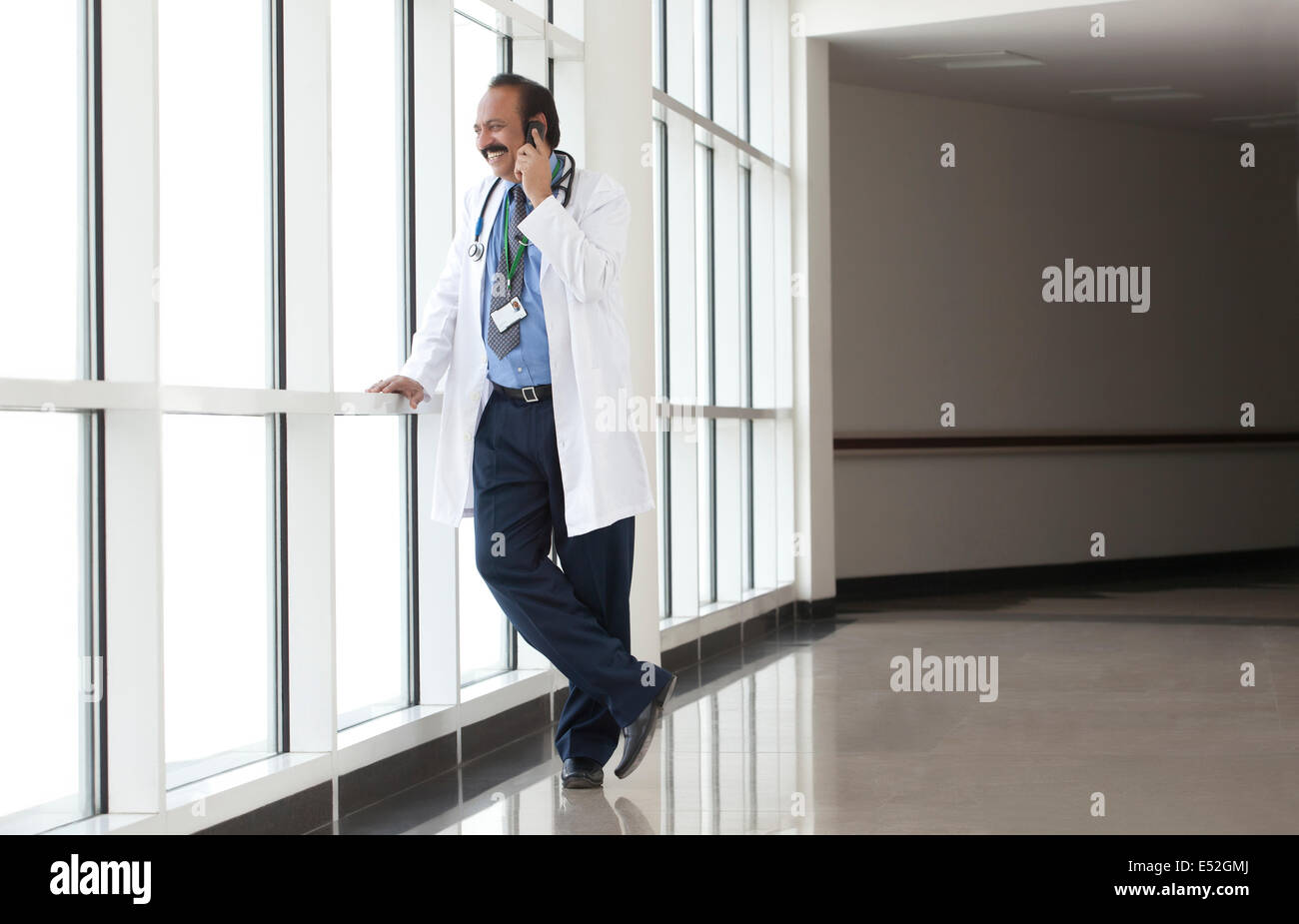 Medico a parlare su un telefono mobile Foto Stock