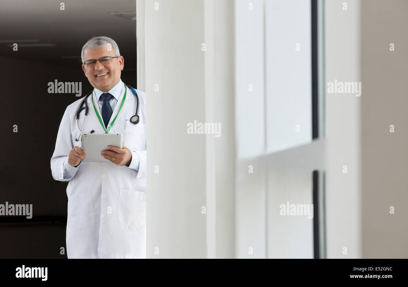 Ritratto di un medico con una tavoletta digitale sorridente Foto Stock