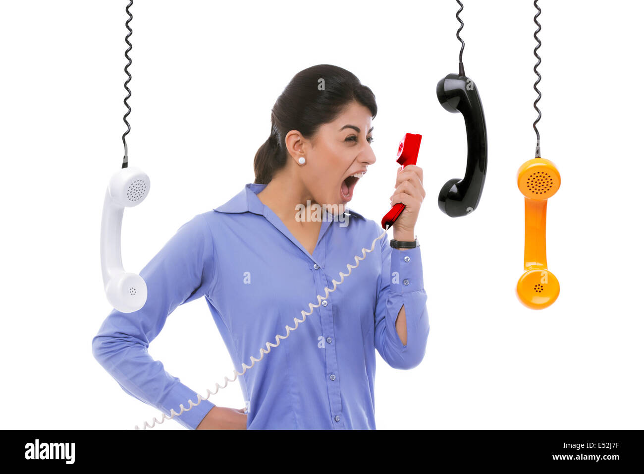 Frustrati imprenditrice urla nel ricevitore del telefono contro uno sfondo bianco Foto Stock