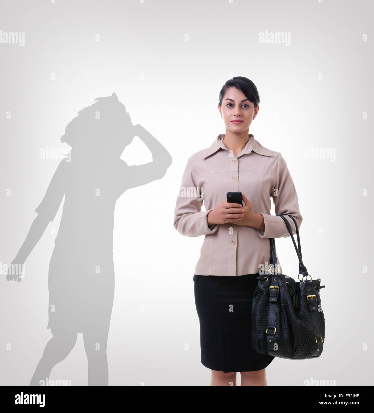 Fiducioso imprenditrice in piedi di fronte a shadow dancing su sfondo grigio Foto Stock