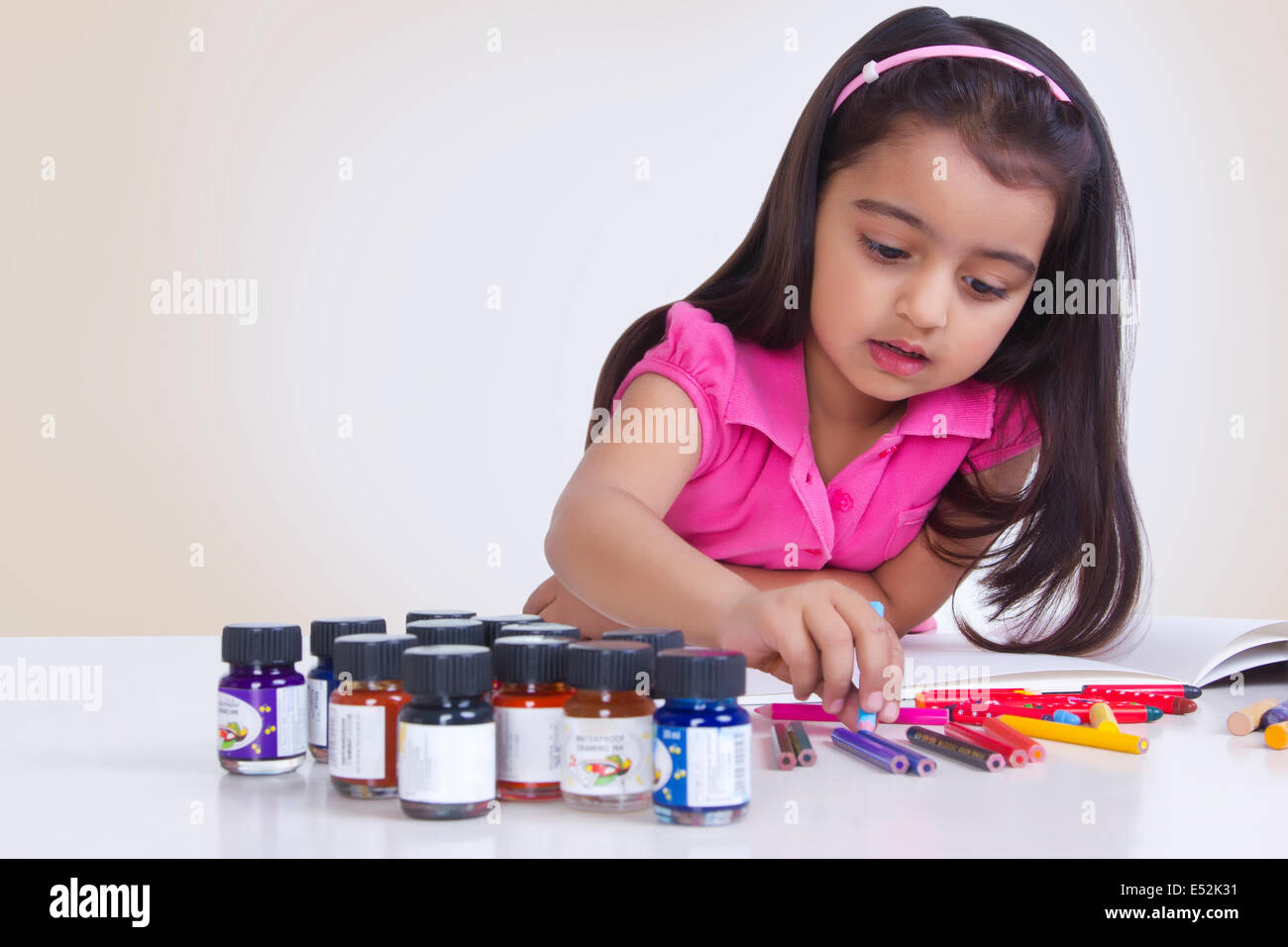 Ragazza carina colorazione a tavola contro uno sfondo bianco Foto Stock