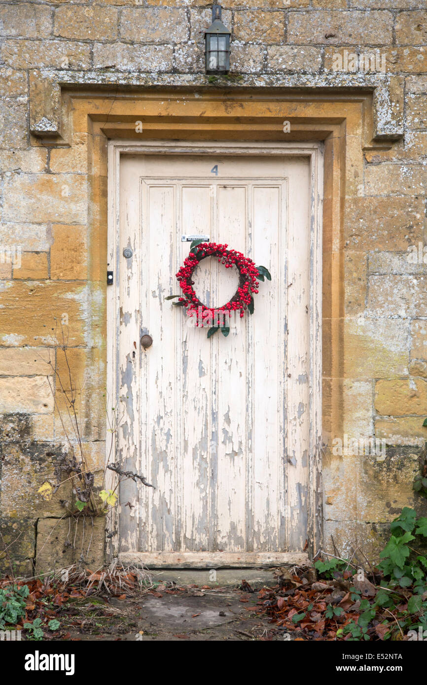 Ghirlanda di Natale sulla vecchia porta cottage, Cotswolds, England, Regno Unito Foto Stock