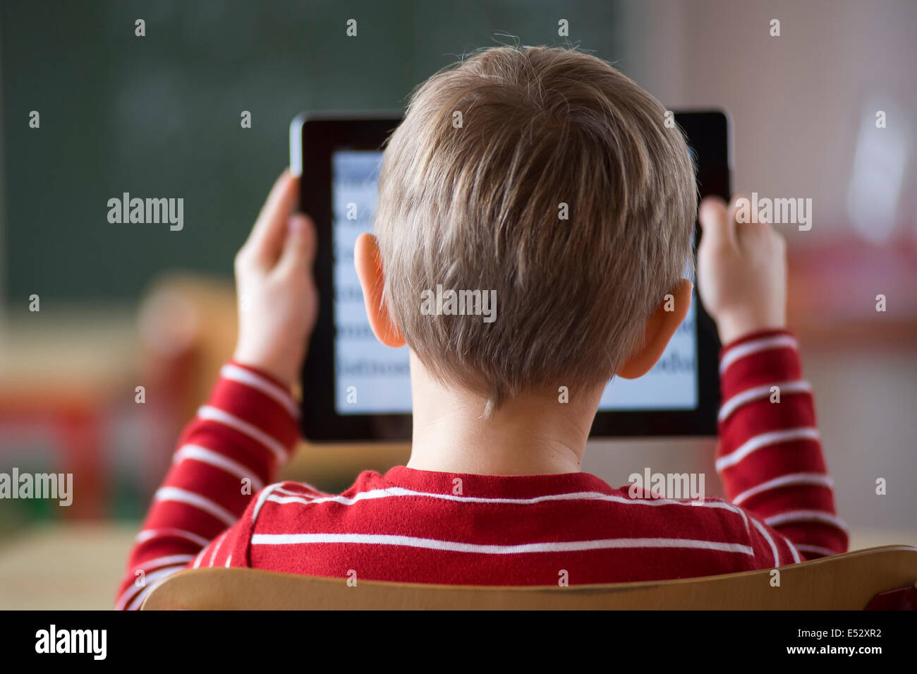 Ragazzo della scuola in classe con iPad Foto Stock