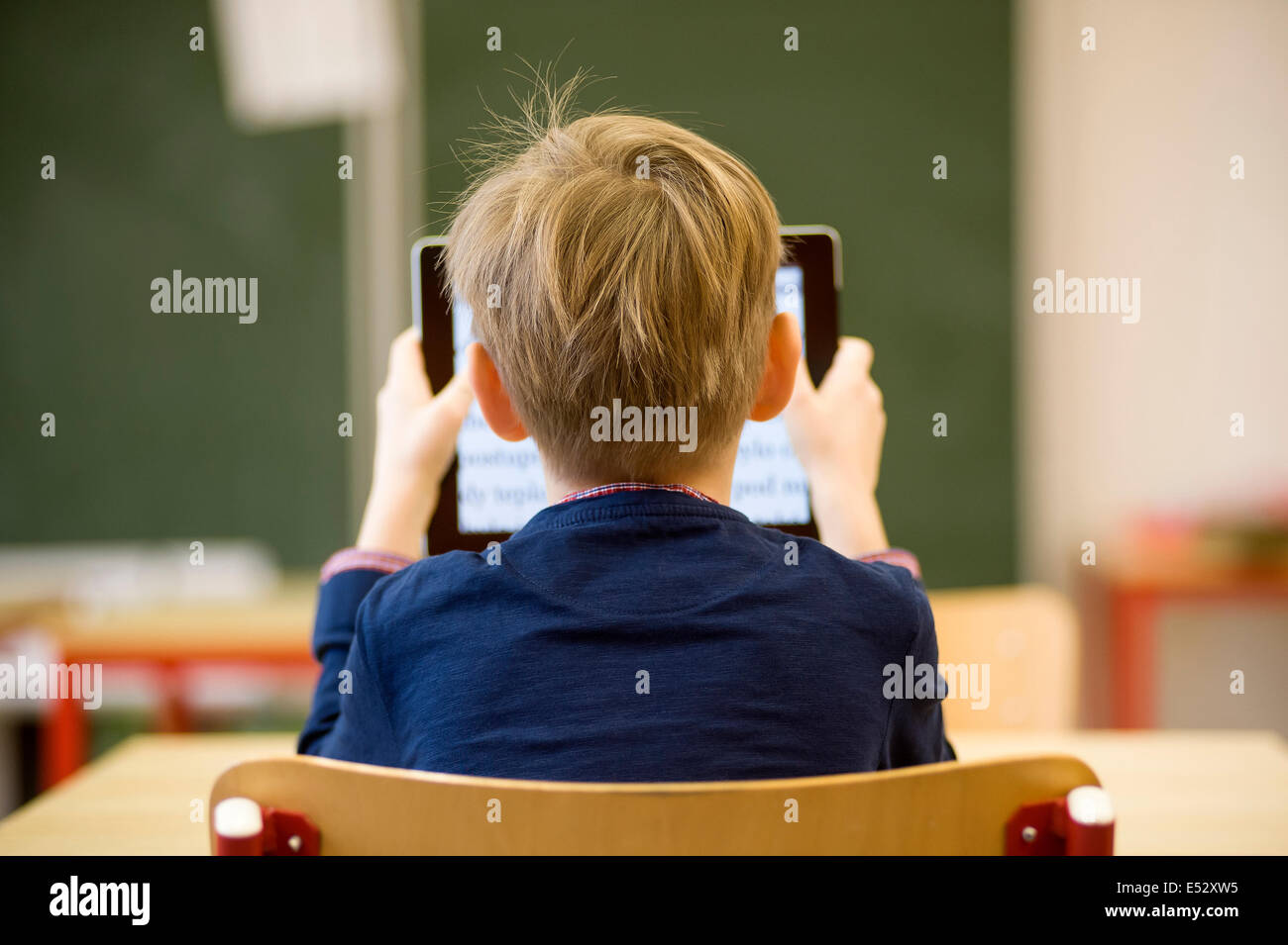 schoolboy in classe con tablet Foto Stock