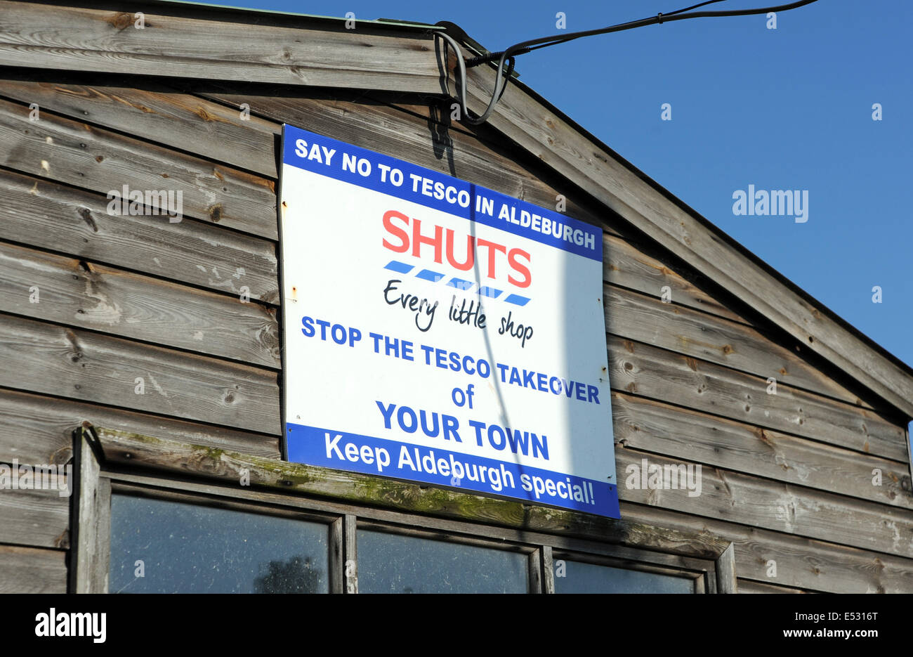 Vista intorno alla città di mare di Suffolk di Aldeburgh supermercato Anti Tesco cartello da presa sul Fishing Hut sulla spiaggia Foto Stock