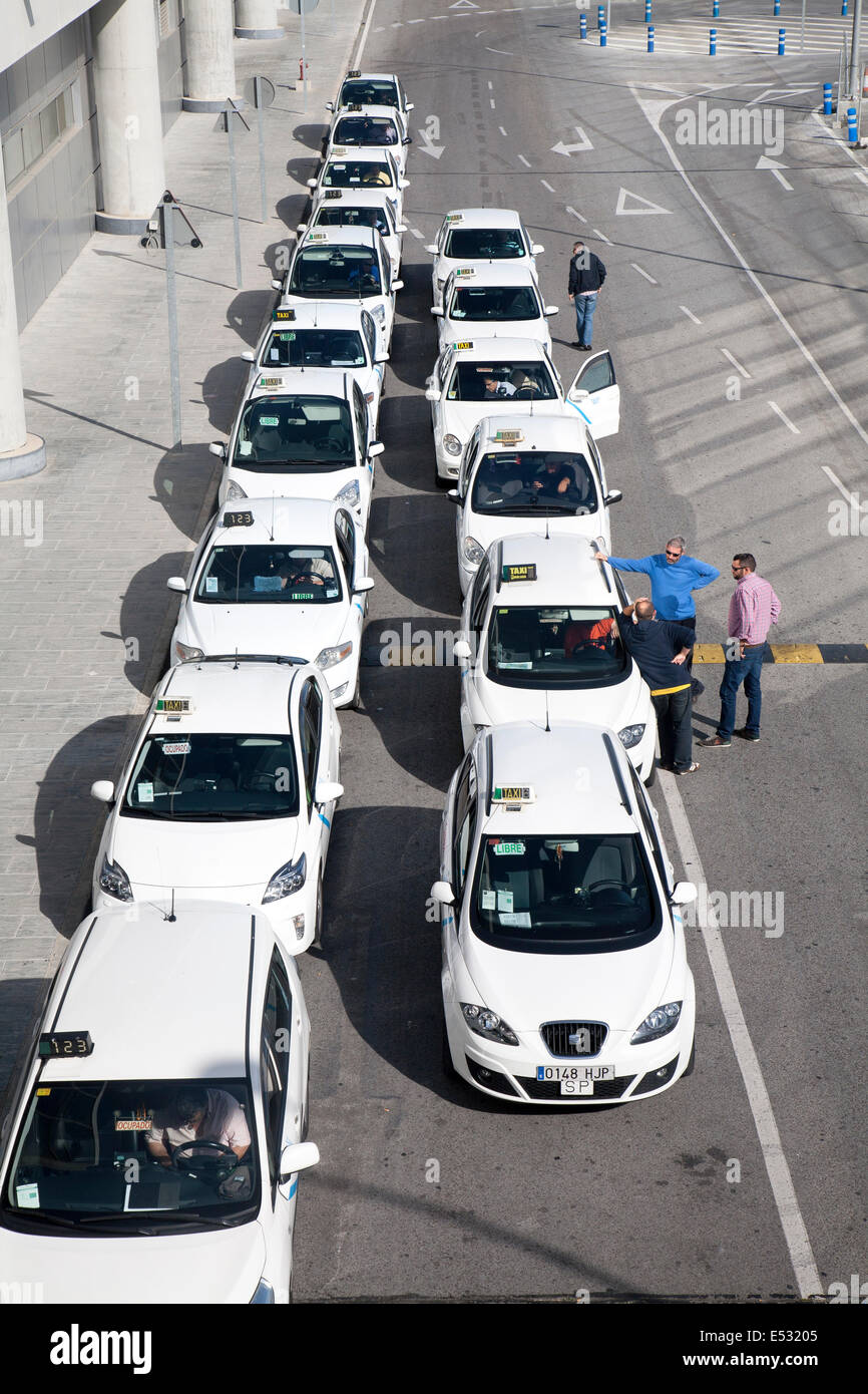 Linea di taxi bianco in coda fuori dall'aeroporto di Malaga, Spagna Foto Stock