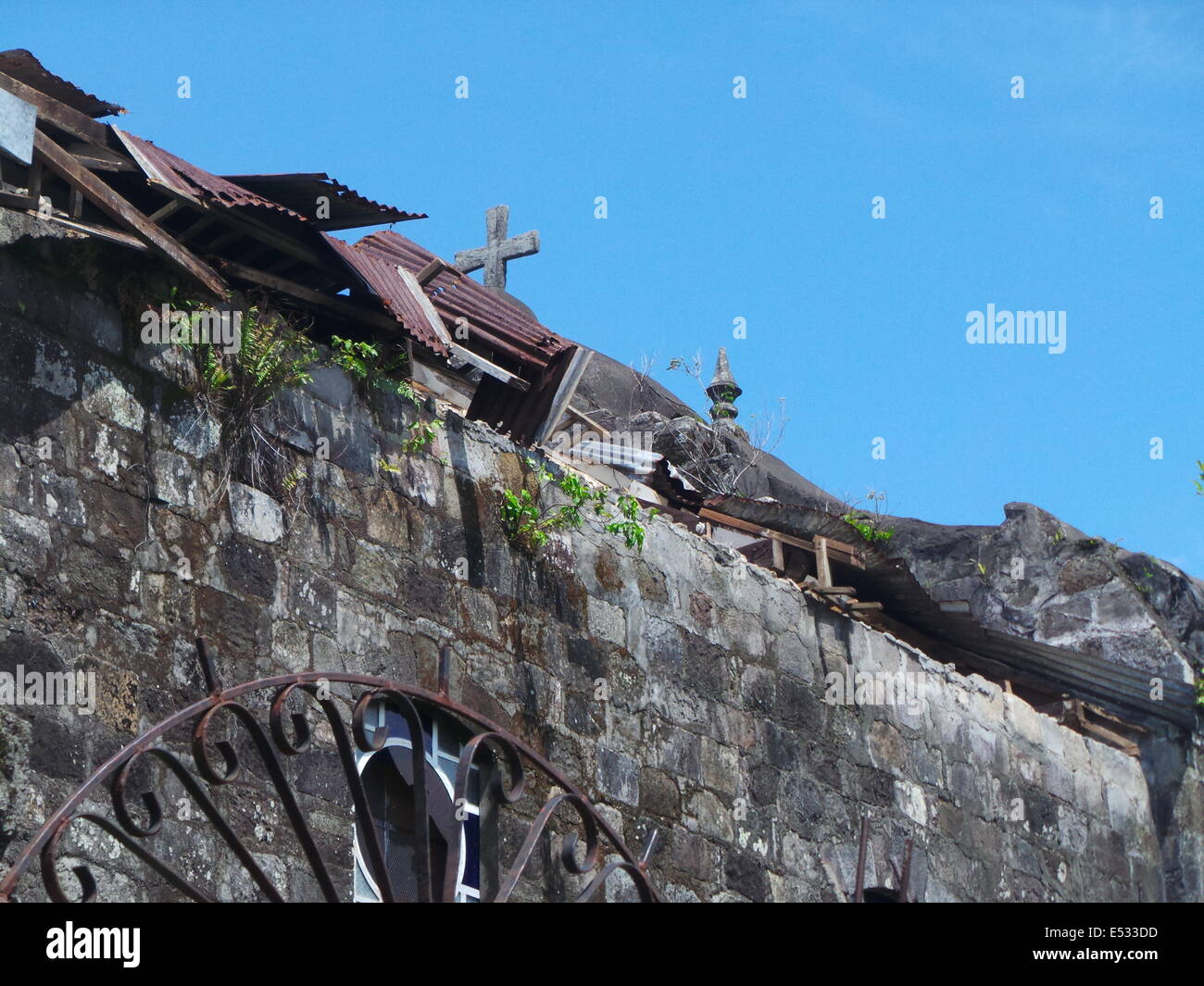 TAYABAS, Filippine - Luglio 18, 2014: Typhoon Glenda (nome internazionale: Rammasun) distrugge la copertura del Santuario de las Almas, conosciuto anche come 'cappella delle anime che è stato costruito nel XV secolo. Il forte e gusty venti di tempesta surge sradicati alberi secolari che circondano la chiesa del patrimonio di Tayabas. Secondo la National la riduzione del rischio di calamità e il Consiglio di Gestione (NDRRMC), nella regione 4-A dove la provincia di Quezon era situato un totale di 4,443 case sono state danneggiate. Foto di Sherbien Dacalanio/Alamy Live News Foto Stock