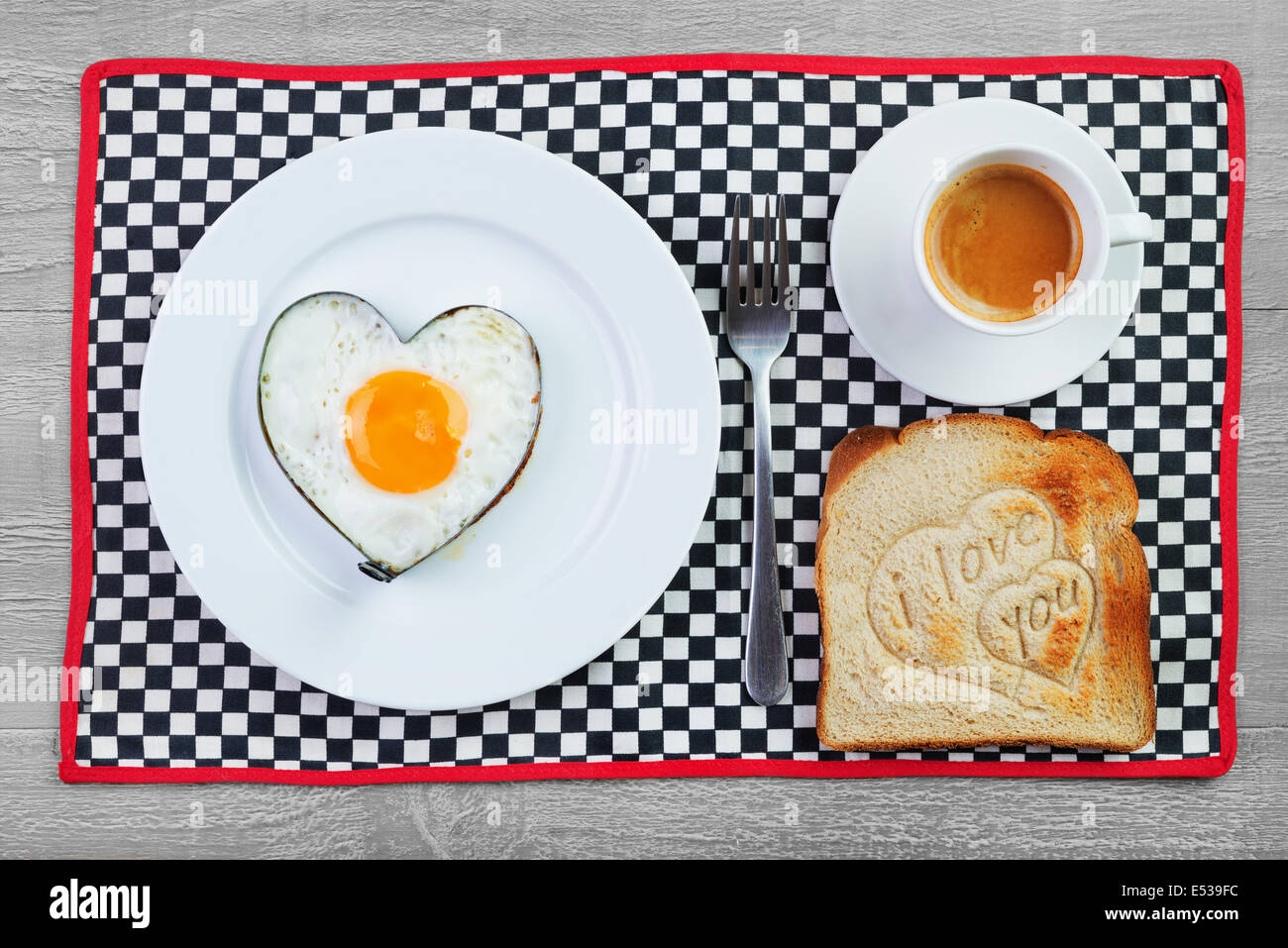 Uovo fritto a forma di cuore e toast con il messaggio di amore.La prima colazione per una persona amata Foto Stock