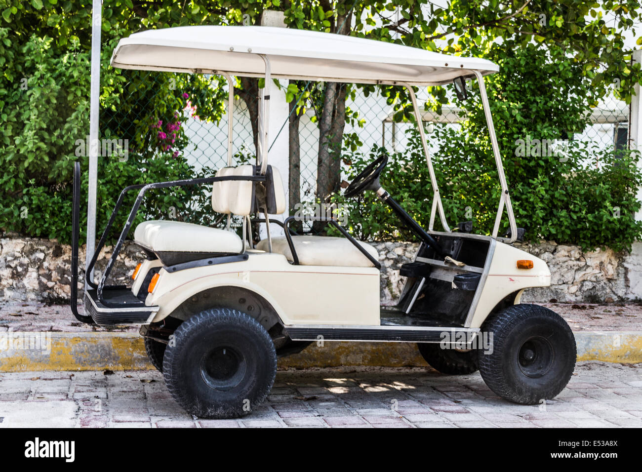 Golf kart parcheggiato per strada in una città di spiaggia Foto Stock