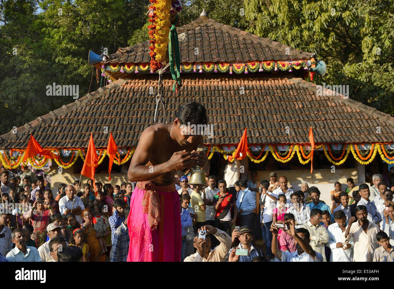 La devota Hindu trafitto da ganci acuti e sollevato dal suolo su una impalcatura utilizzando corde. Konkan, Maharashtra, India Foto Stock La devota Hindu trafitto da ganci acuti e sollevato dal suolo su una impalcatura utilizzando corde. Konkan, Maharashtra, India Foto Stock