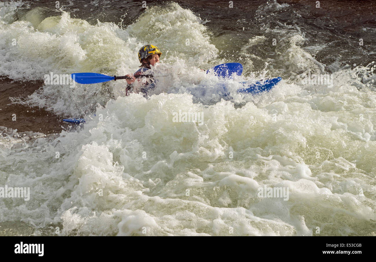 Canoeist getting molto wet white acqua canoa kayak a Cardiff White Water Centre Wales UK Foto Stock