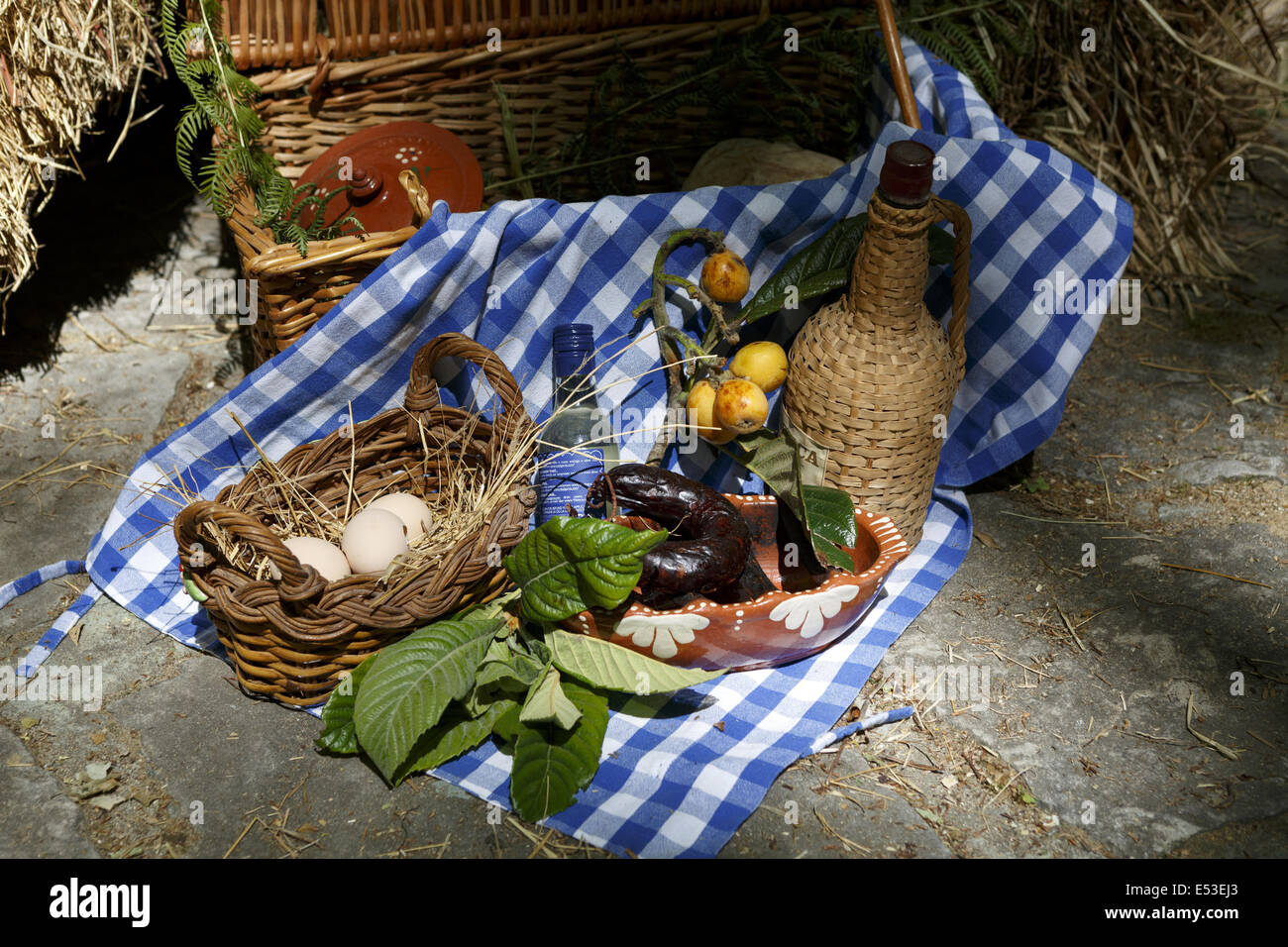 In vimini cesto da picnic e avvolto in vimini Boccale vino in un ambiente rustico Foto Stock