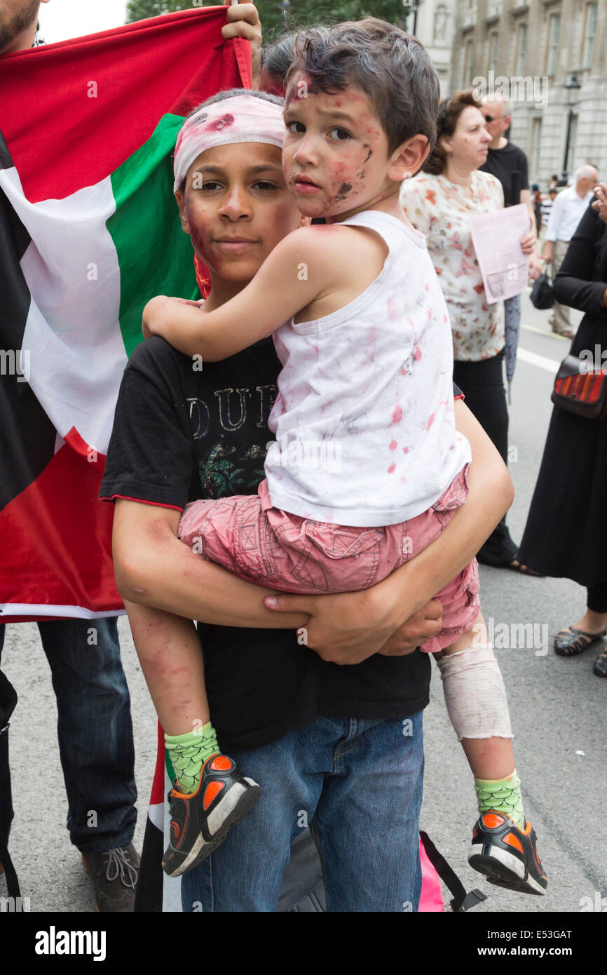 Londra, Regno Unito. Il 19 luglio 2014. Bambini palestinesi sono realizzati con sangue finto. Decine di migliaia di manifestanti dalla Palestina, in Gran Bretagna e in tutto il mondo chiede a Israele di porre fine alla sua azione militare a Gaza. Il marzo insieme fuori da Downing Street/Whitehall ed è dovuta per terminare presso l Ambasciata di Israele in Kensington più tardi questo pomeriggio. Foto: Nick Savage/Alamy Live News Foto Stock