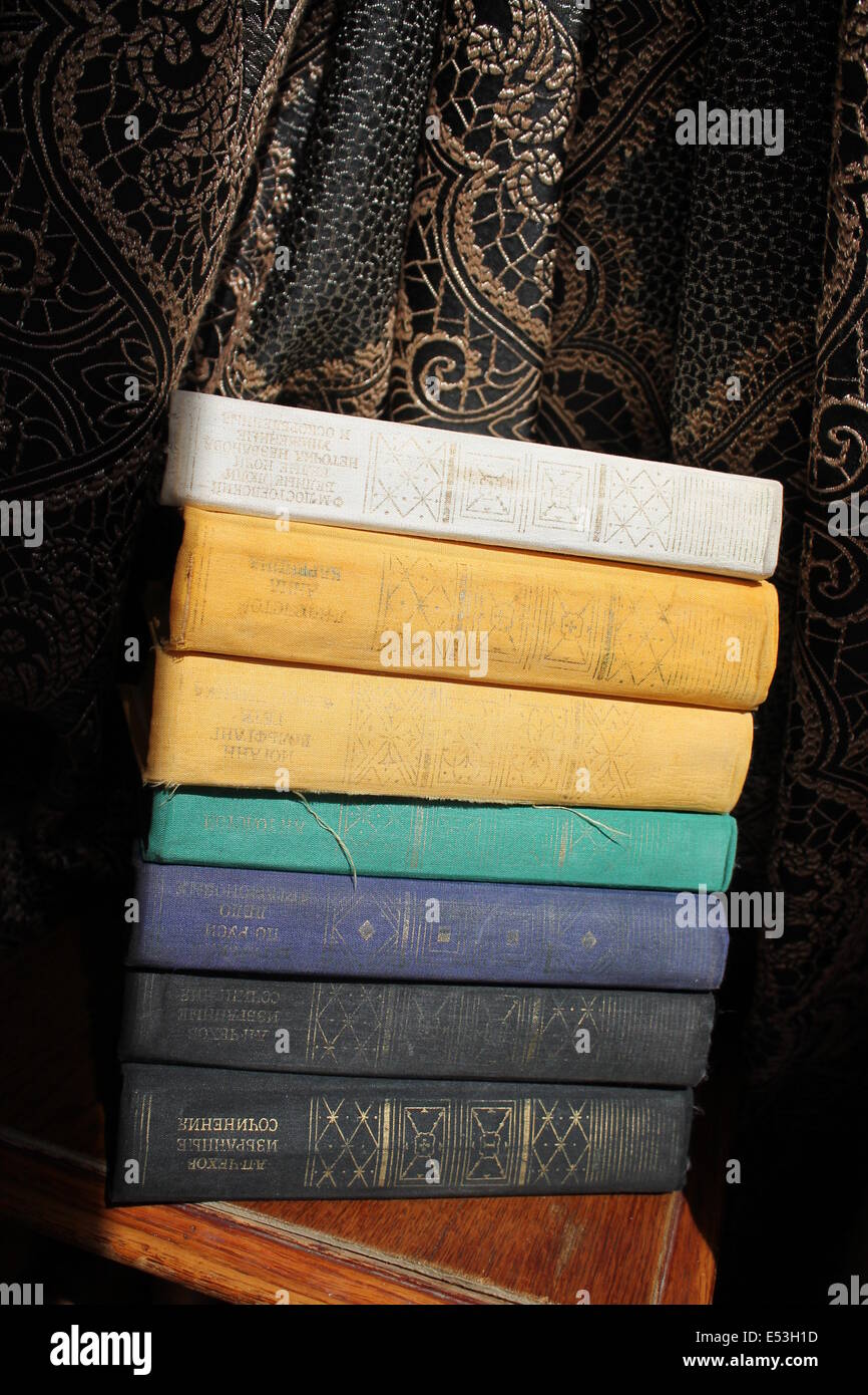 Vecchi libri sottili in tessuto copre i laici nel mucchio Foto Stock