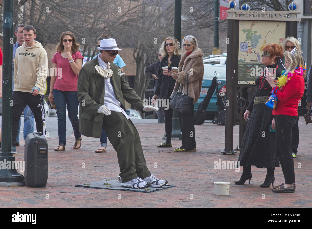 ASHEVILLE, North Carolina, Stati Uniti d'America - 2 Marzo 2014: UN MASCHIO statua vivente street performer sembra essere soffiata all'indietro dal vento. Foto Stock