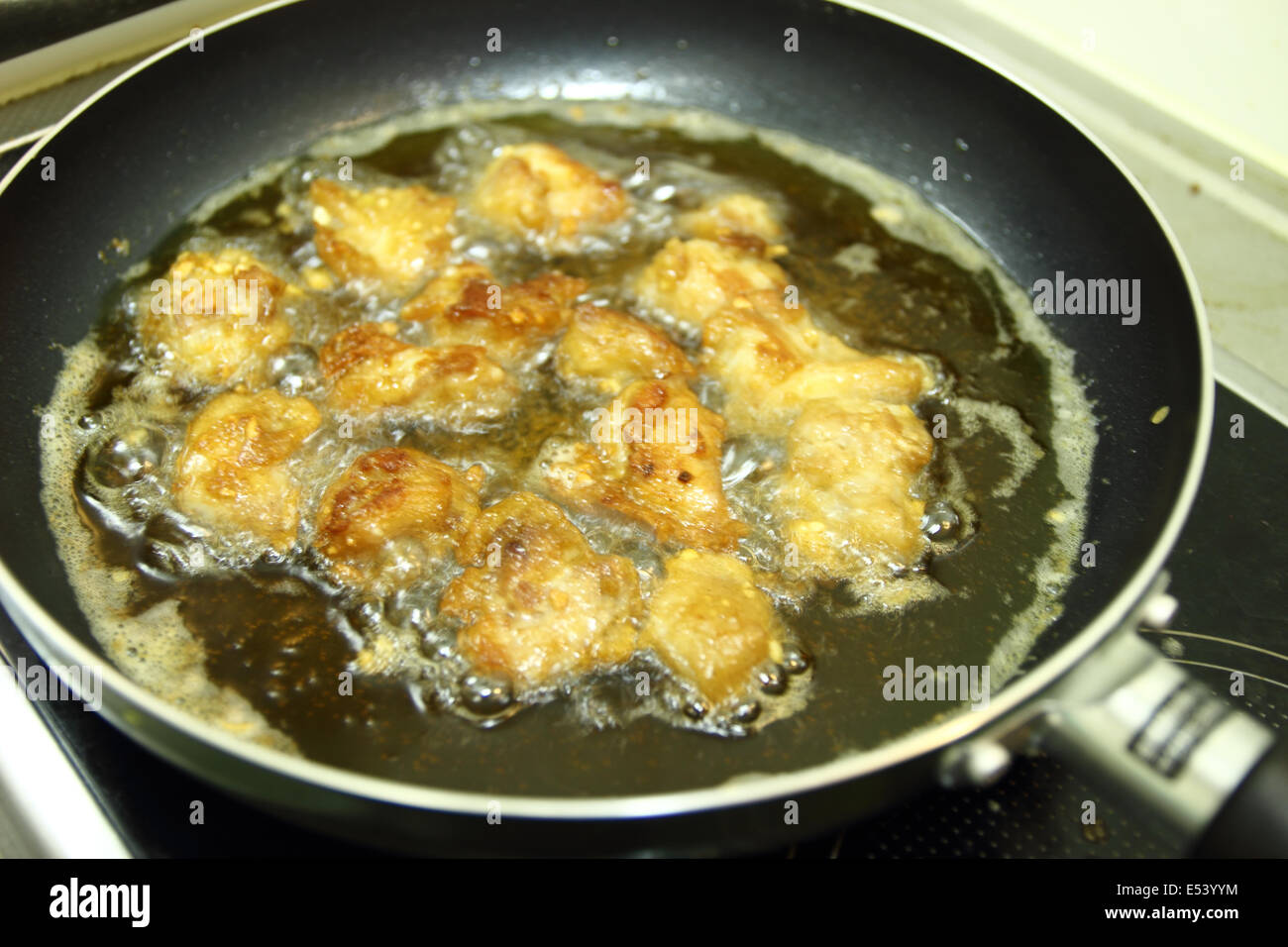 Pepite di pollo in acqua calda per la cottura olio su una padella Foto Stock