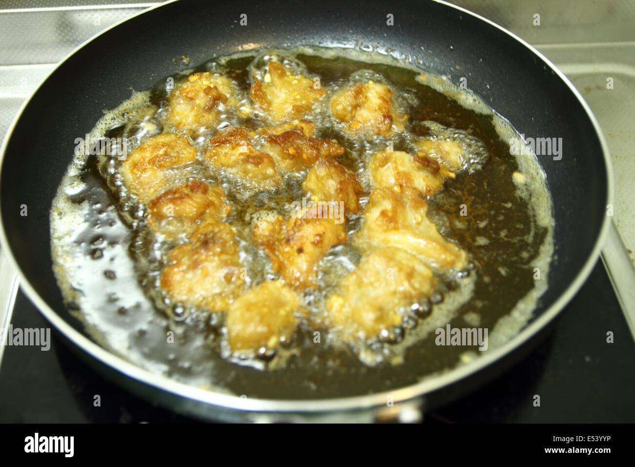 Pepite di pollo in acqua calda per la cottura olio su una padella Foto Stock
