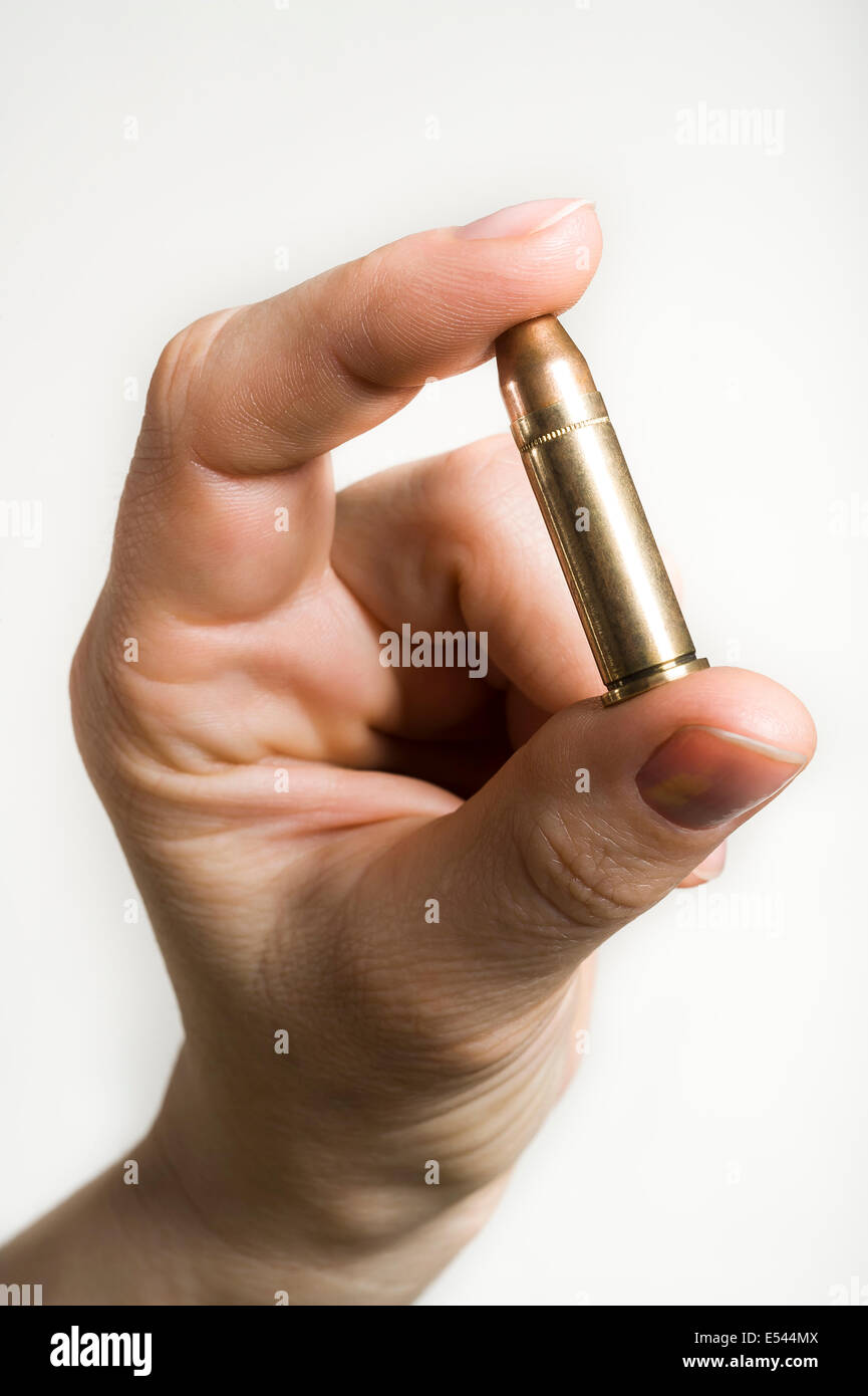 Mano che tiene un proiettile Foto Stock