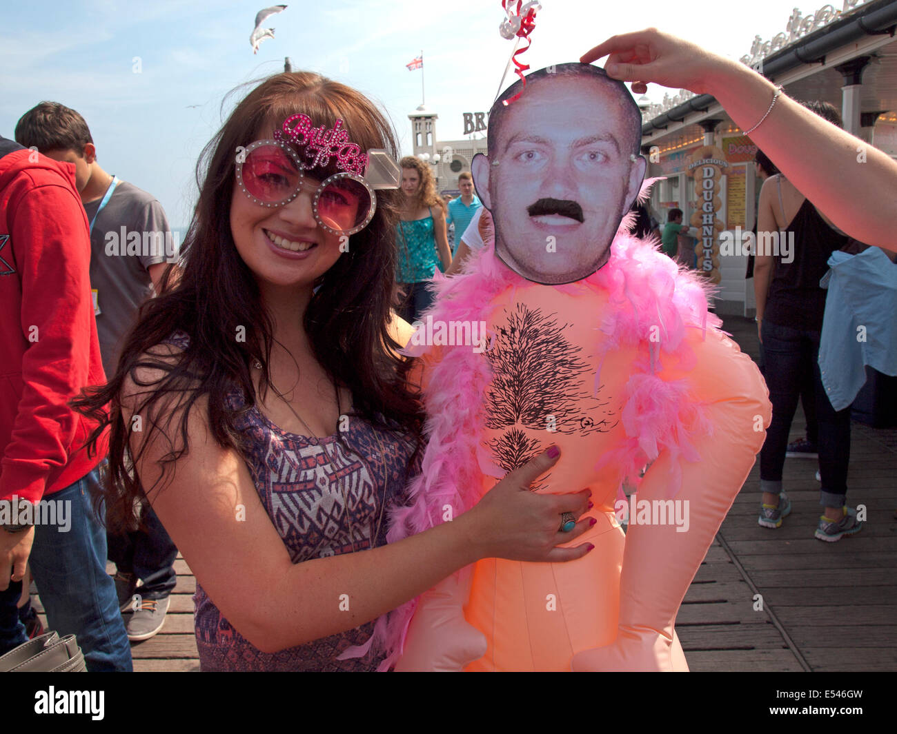 Una promessa sposa detiene un'effigie del suo futuro marito sul molo di Brighton Foto Stock