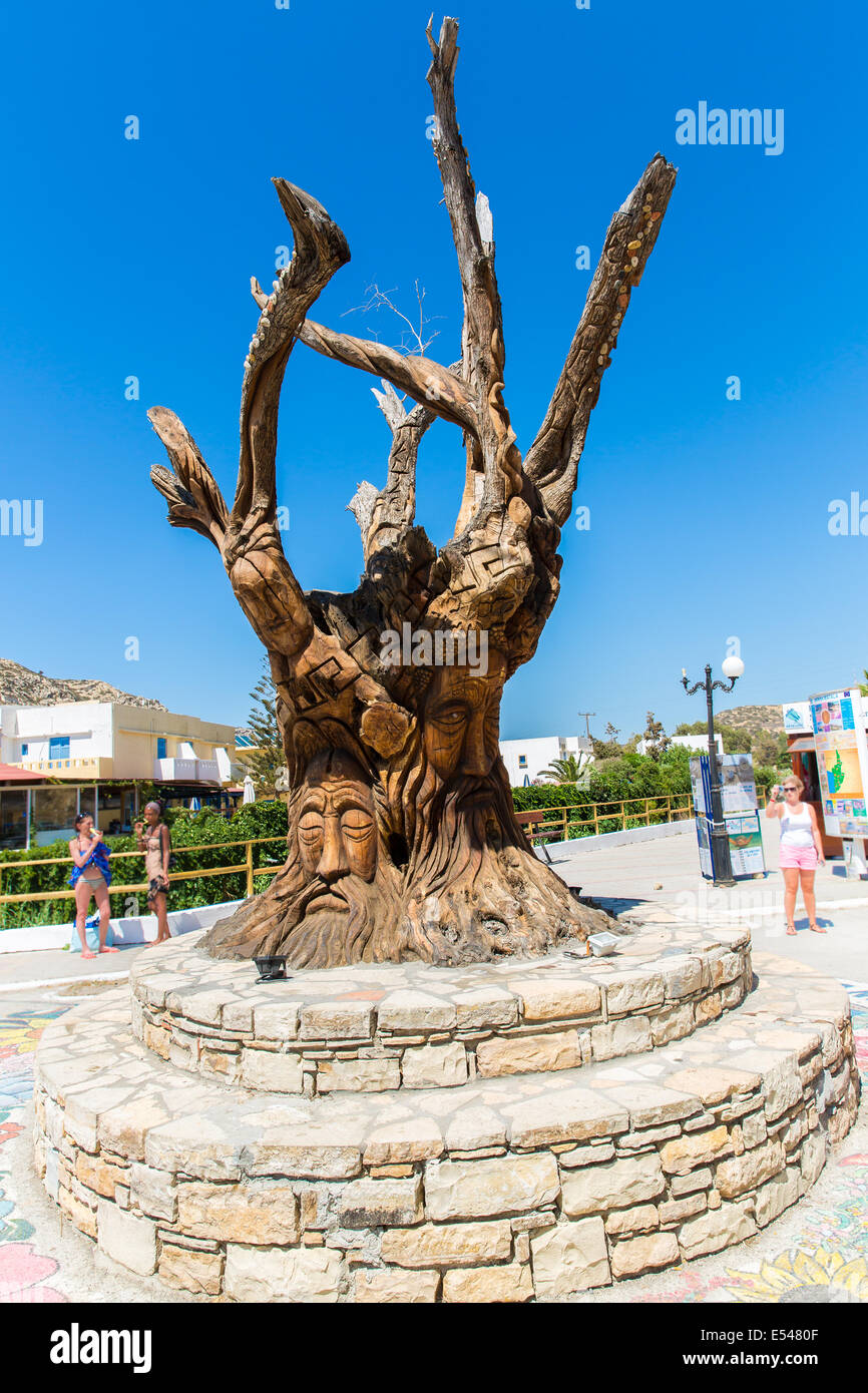 Albero con un volto scolpito sulla piazza di Matala, Grecia Creta. Foto Stock