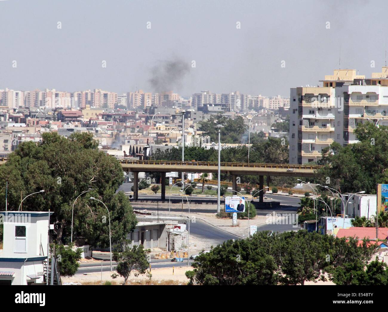 Tripoli. Il 20 luglio, 2014. Il fumo sale dalle strade vicino a Tripoli Aeroporto internazionale come un pesante combattimento prosegue tra milizie rivali gruppi sulla luglio 20, 2014, a Tripoli, in Libia. Credito: Hamza Turkia/Xinhua/Alamy Live News Foto Stock