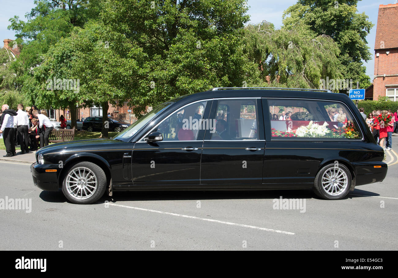 Jaguar funebre trasporta un rosso e bianco bara colorata in un corteo funebre Marlow Buckinghamshire REGNO UNITO Foto Stock