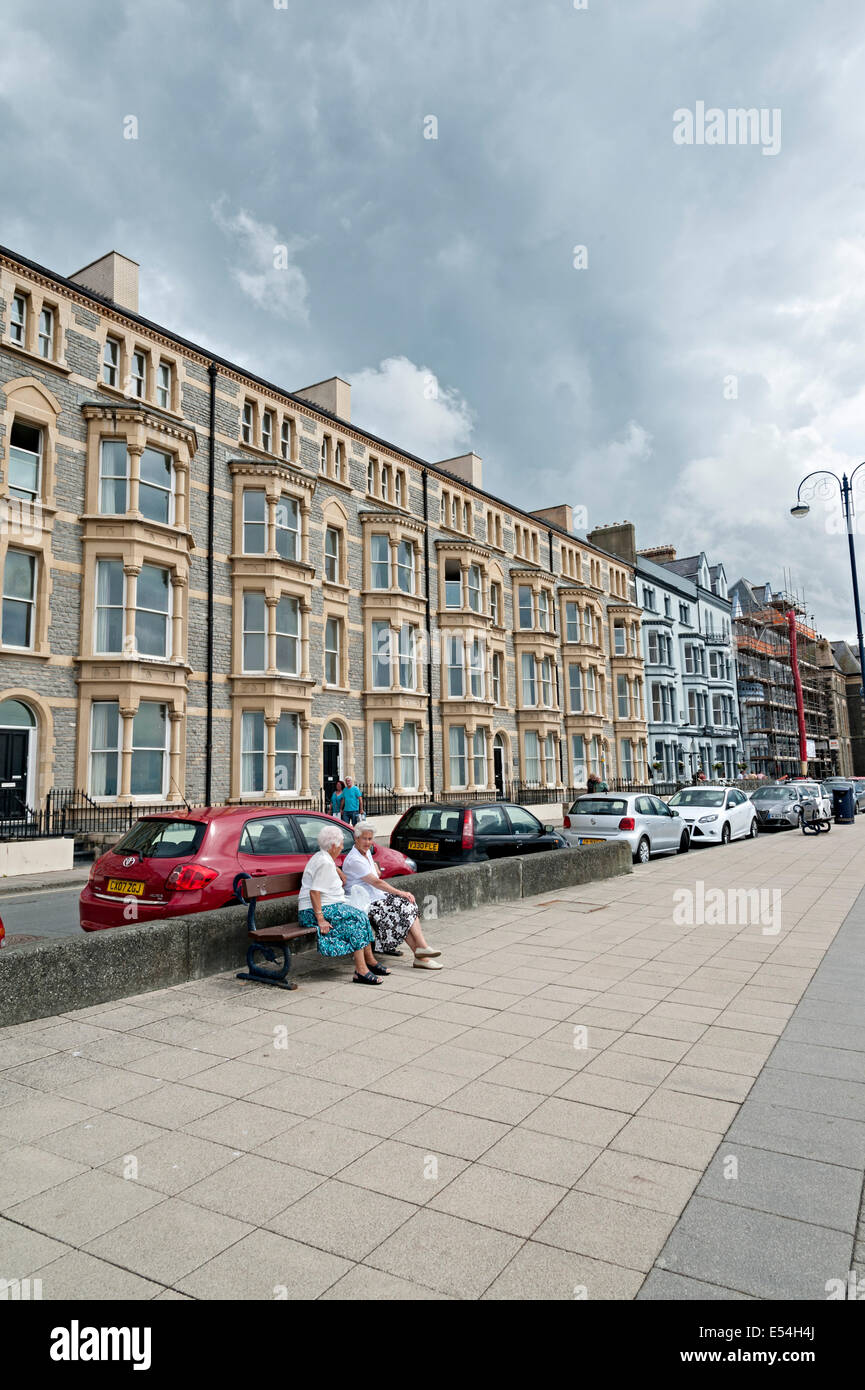 Due anziani seduti su una panchina guardando oltre il lungomare e la baia di Aberystwyth wales Foto Stock Due anziani seduti su una panchina guardando oltre il lungomare e la baia di Aberystwyth wales Foto Stock
