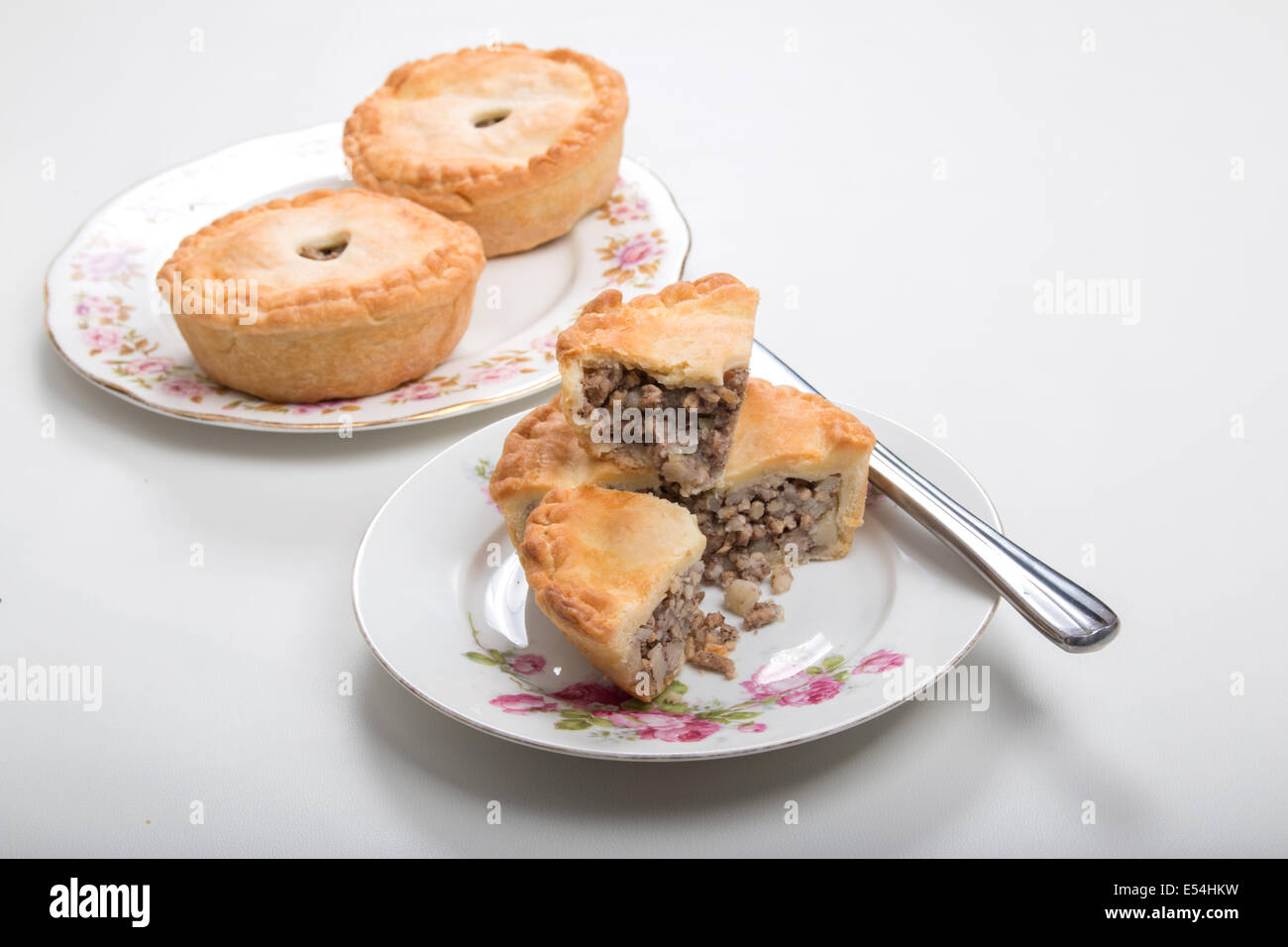 Piccoli pasticci di carne su piastre fiorito, coltello sulla piastra , tagliato per mostrare il riempimento di tritato./la carne macinata di maiale (17 di 20) Foto Stock