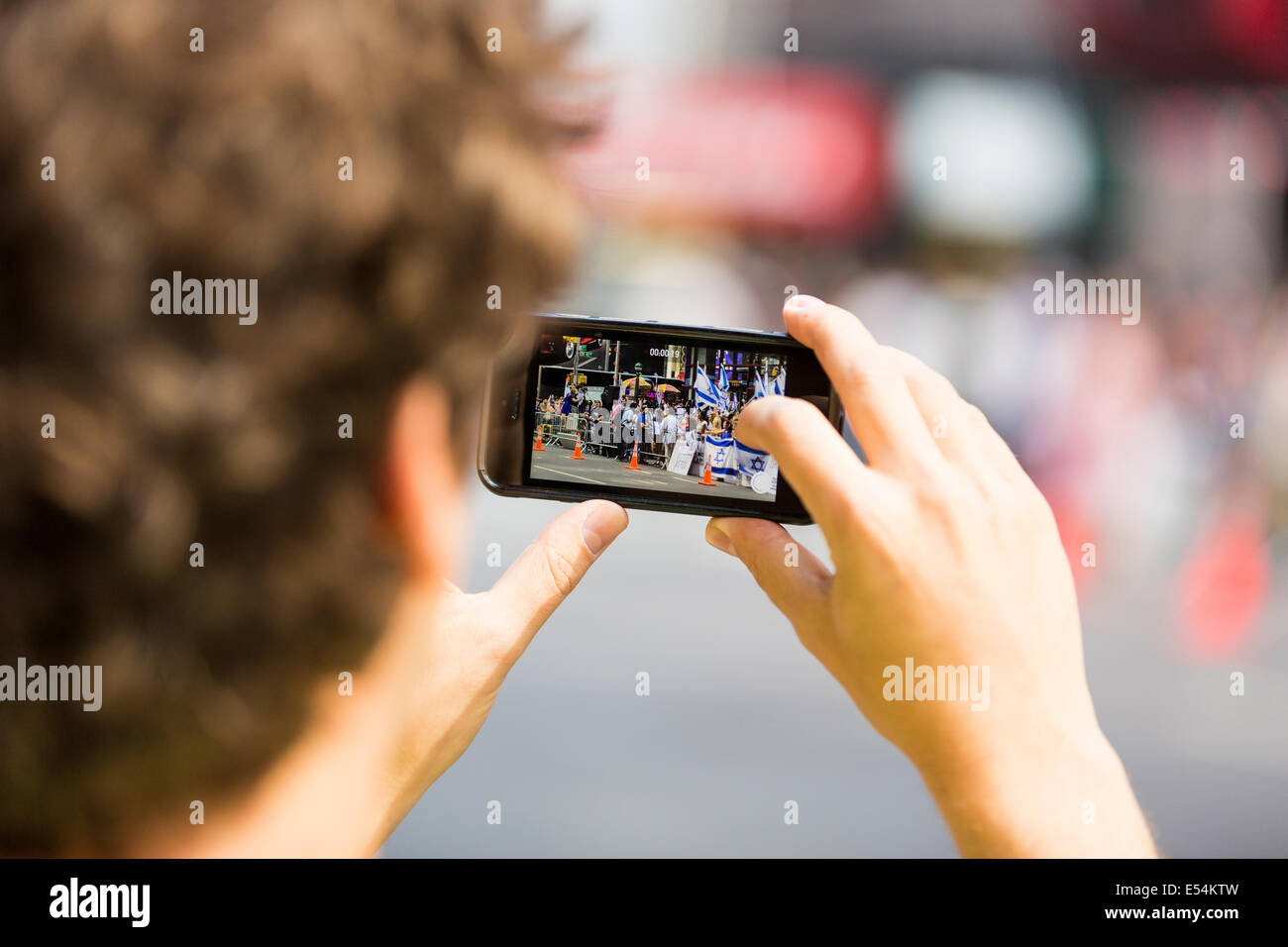 L'uomo scattare una fotografia con un iPhone, smartphone utilizzando la sua mano destra dito indice Foto Stock