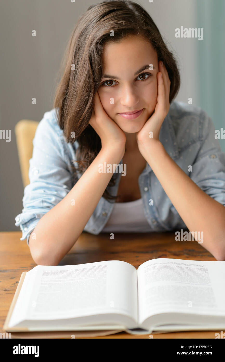 Ragazza adolescente godetevi la lettura libro studente a casa Foto Stock