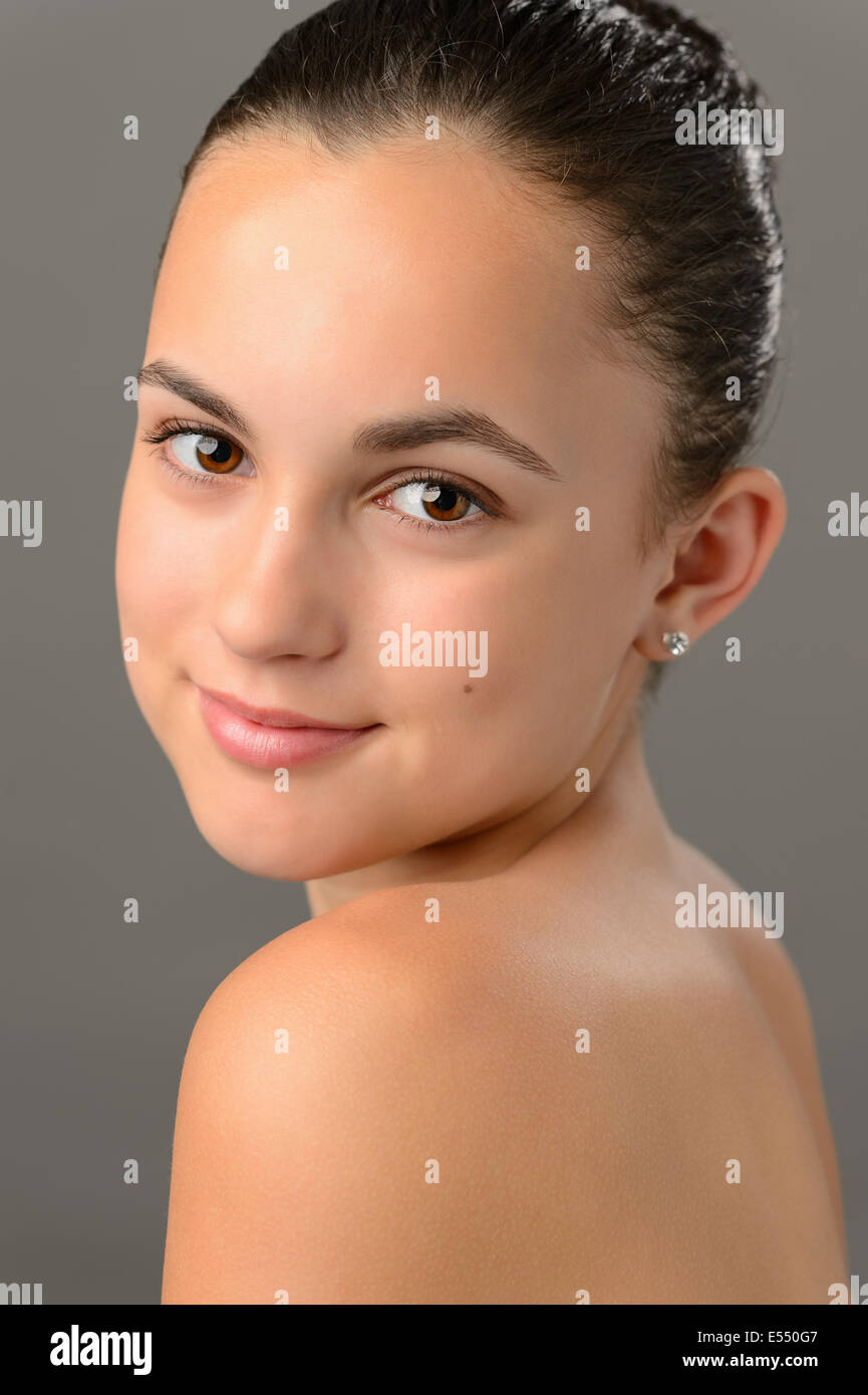 Ragazza adolescente a spalle nude pelle bellezza viso ritratto su grigio Foto Stock